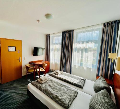 um quarto de hotel com uma cama e uma secretária em Hotel-Pension "Petridamm" em Rostock