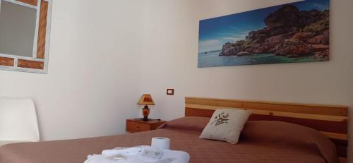 カステッランマーレ・デル・ゴルフォにあるNonna Giò Houseのベッドルーム1室(ベッド1台付)が備わります。壁に絵が飾られています。