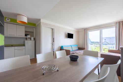 une cuisine et une salle à manger avec une table et des chaises dans l'établissement Les Ondines, à Courseulles-sur-Mer