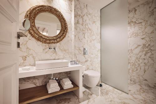 uma casa de banho com um lavatório e um espelho em AK Mykonos em Míconos