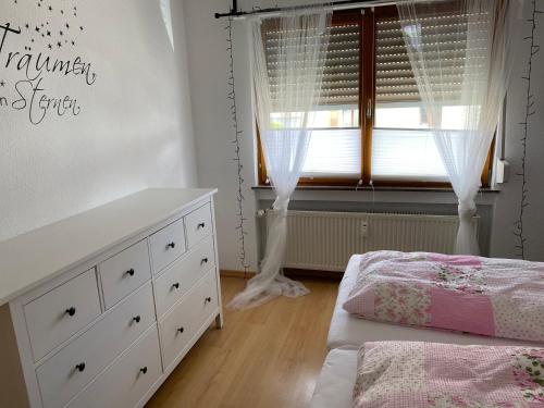 a bedroom with a bed and a dresser and a window at Fewo Weinland in Zweibrücken