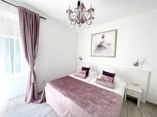 een witte slaapkamer met 2 bedden en een kroonluchter bij Bed&Breakfast Sorgo Palace in Ston