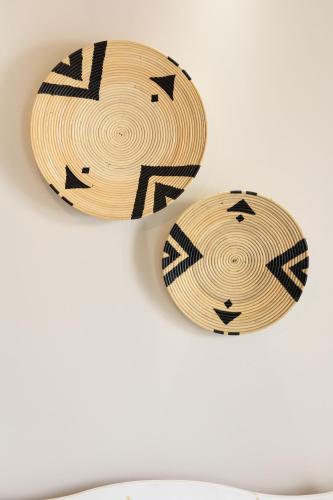 two wooden plates with black and white designs on a wall at Emery Hotel in Naxos Chora