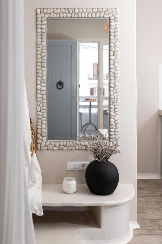 a bathroom with a mirror and a vase on a table at Emery Hotel in Naxos Chora