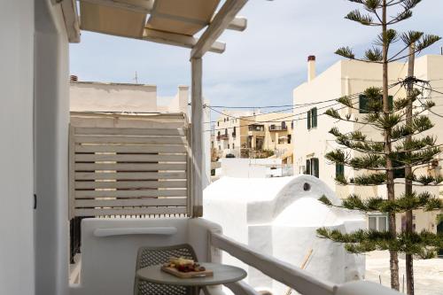 a balcony with a table and a tree at Emery Hotel in Naxos Chora