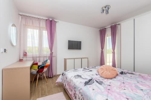 a bedroom with a bed and a desk and window at Villa QUERCUS in Krk