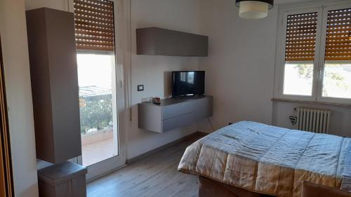サヴォーナにあるCasetta Sonayのベッドルーム(ベッド1台、テレビ、窓付)