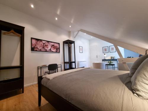 Un dormitorio con una cama y una mesa con una silla. en Stableyard cottages, en Lamorlaye