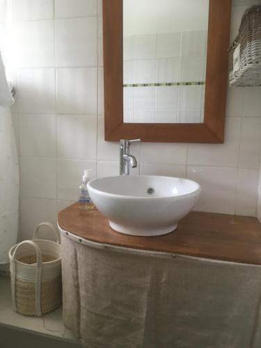 een badkamer met een witte wastafel en een spiegel bij Auprès du château in Brézé