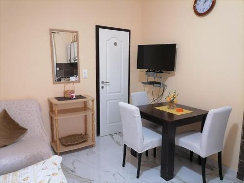 a living room with a table and chairs and a tv at Romana 1 in Tivat