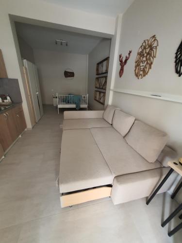 a living room with two beds and a couch at New apartment ,50m from the sea at Nea Irakleia. in Nea Irakleia