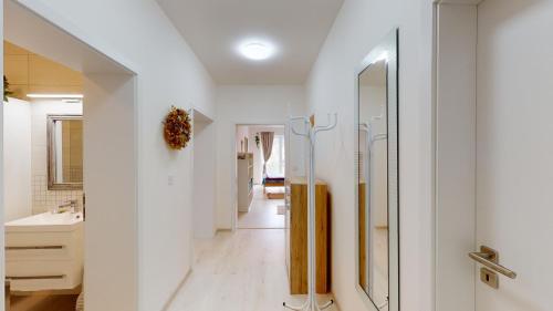 een witte badkamer met een wastafel en een spiegel bij Apartmán Michaela Luhačovice in Luhačovice