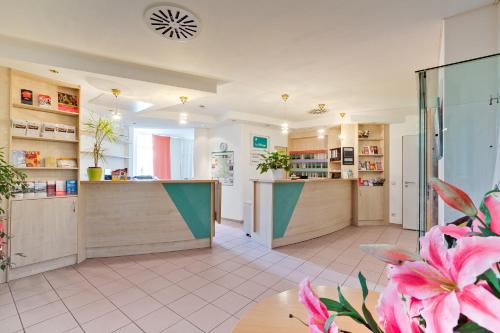 a large room with a kitchen with a counter at Hotel Le Village in Winnenden