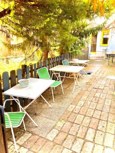ein paar Tische und Stühle neben einem Zaun in der Unterkunft Apartment Liesingbach in Wien