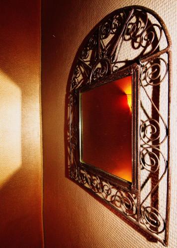 a mirror on a wall with a reflection of a room at Résidence LE11B in Uzerche