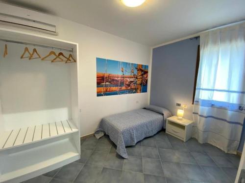 a small bedroom with a bed and a window at 103 Boutique Hotel Stintino in Stintino