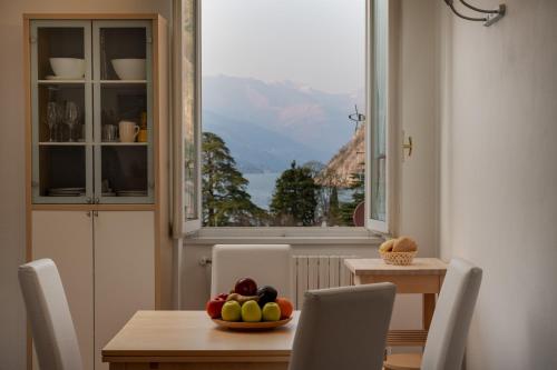 a dining room with a table with a bowl of fruit at Casa Sole in Varenna