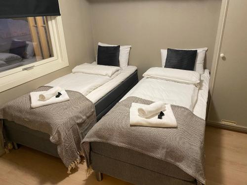 two beds with towels on them in a room at Big central house, free parking, wifi, 3 bedrooms in Narvik