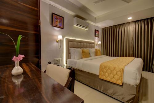 a hotel room with a bed and a table at Elite Hotel in Lonavala
