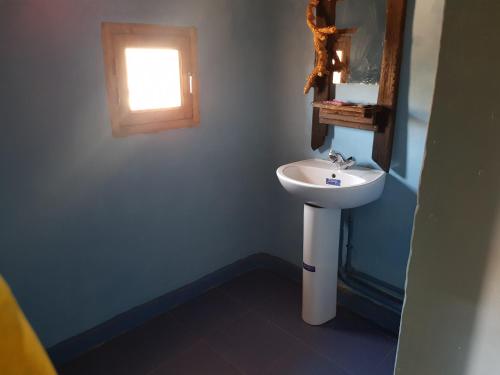 a bathroom with a white sink and a window at ecolodge bivouac des aigles in Ouarzazate