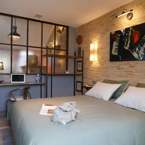 une chambre avec un grand lit avec un livre dessus dans l'établissement In Sarlat Luxury Rentals, Medieval Center - Loft Stella Matutina -2p-ascenseur-climatisation, à Sarlat-la-Canéda