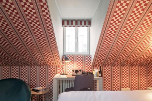 a bedroom with a bed and a desk and a window at The Sparrow Hotel in Stockholm