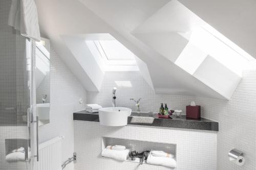 a bathroom with a sink and a skylight at The Sparrow Hotel in Stockholm