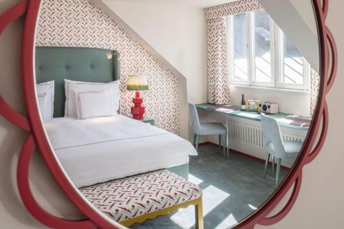a bedroom with a bed and a desk in a mirror at The Sparrow Hotel in Stockholm