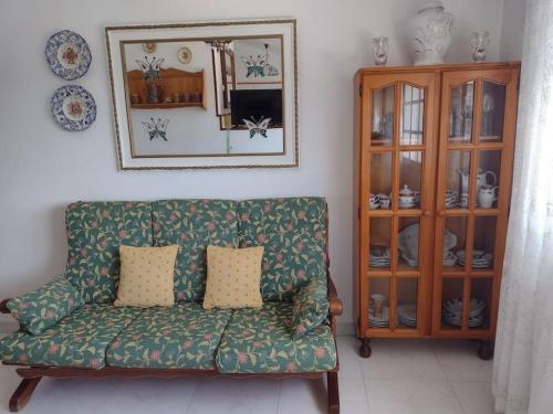 sala de estar con sofá verde y armario en Precioso apartamento en San Vicente de O Grove, en San Vicente de O Grove