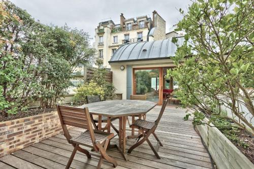 une table et des chaises en bois sur une terrasse en bois dans l'établissement Appartement Dombasle Tour Eiffel - Welkeys, à Paris