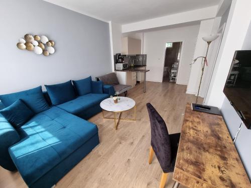 a living room with a blue couch and a table at Apartment Residence Bratislava FREE PARKING in Bratislava
