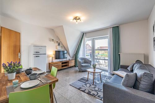 a living room with a couch and a table at Meer Appartement in Büsum