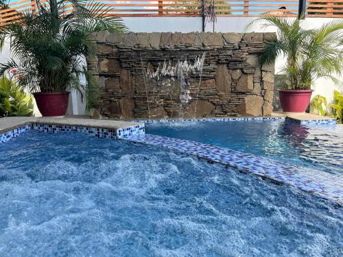 a swimming pool in a backyard with a stone wall at Casa Cecilia Hotel in Bantay