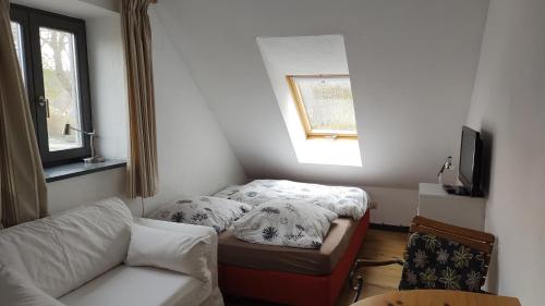 アンガーミュンデにあるFerienwohnung in Peetzig am Seeのソファとベッド付きの小さな部屋です。