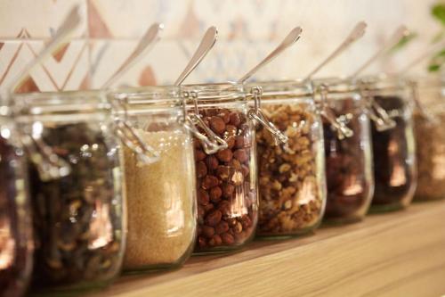 a row of glass jars filled with nuts and seeds at Scandic Wrocław in Wrocław