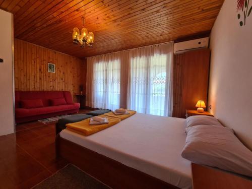 a bedroom with a large bed and a red couch at Apartments Zlatko 1397 in Štinjan