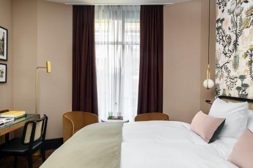 a hotel room with a bed and a desk and a window at Boutique Hotel Seidenhof in Zürich