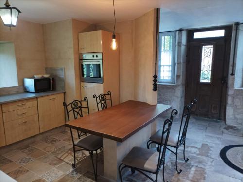 cocina con mesa de madera y sillas en La maison du meunier, en Autigny-la-Tour