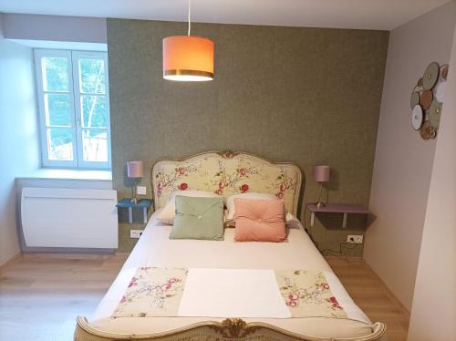 a bedroom with a bed with pillows on it at La maison du meunier avec terrain de pétanque in Autigny-la-Tour
