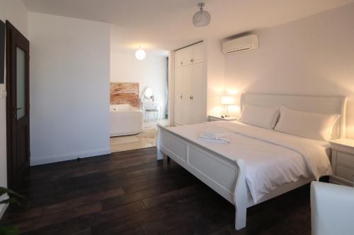 a bedroom with a white bed and a bathroom at Perla Sudului - Residence in Timişoara