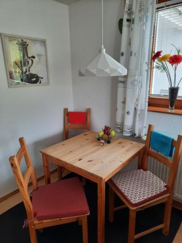 uma mesa de jantar com 2 cadeiras e uma mesa de madeira em Ferienwohnung Am Wald em Bad Herrenalb