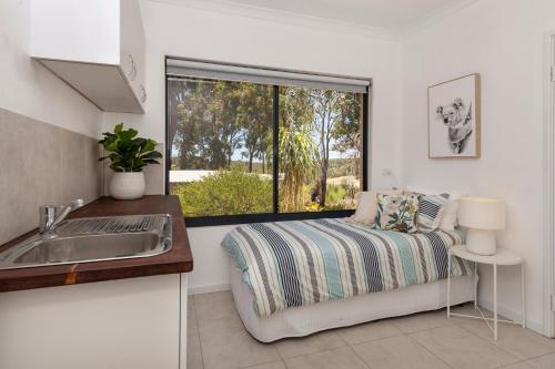a kitchen with a bed and a sink and a window at Twilight Ridge - Situated on 2 acres of pristine bushland, Twilight Ridge offers both privacy and space in Quindalup