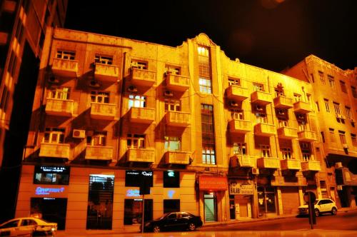 a large building on a street with cars parked in front at New Park Hotel in Amman