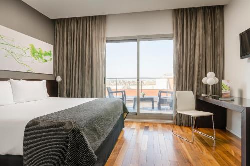 Habitación de hotel con cama y balcón en Ikonik Lex, en Hospitalet de Llobregat