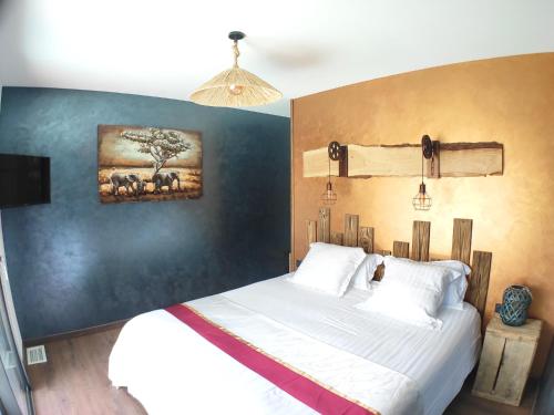 a bedroom with a large bed with a blue wall at Villa Occitana in Calvisson