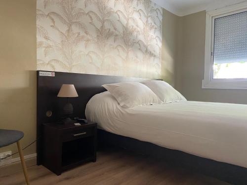 a bedroom with a large bed with a wall at Hotel Regina in Sète
