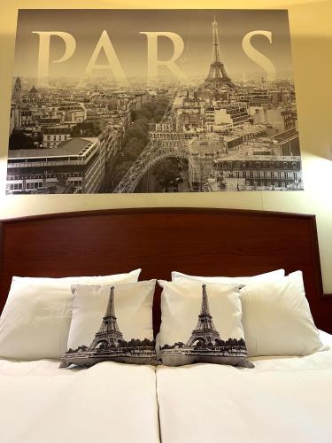 a picture of the eiffel tower is above a bed at Your Home (YH) in Yerevan