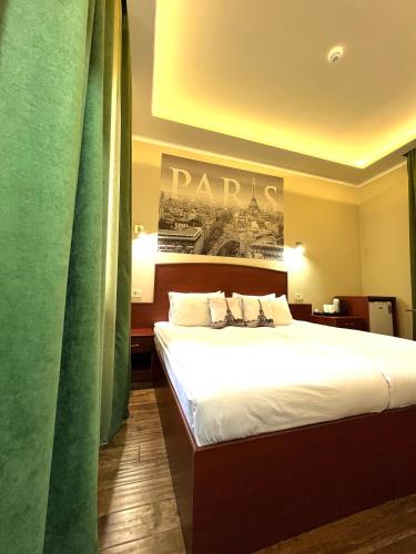 a hotel room with a bed and a sign on the wall at Your Home (YH) in Yerevan
