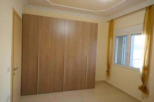 a large wooden cabinet in a room with a window at Top Relax in Vlorë