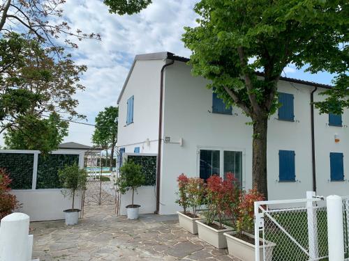 a white house with potted plants in front of it at Il Giullare by agriturismo Borgo Castellaccia in Cesenatico